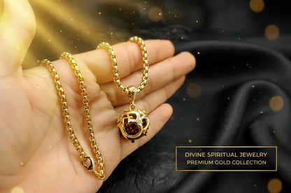 Gold necklace with OM pendant held in a hand against a dark background